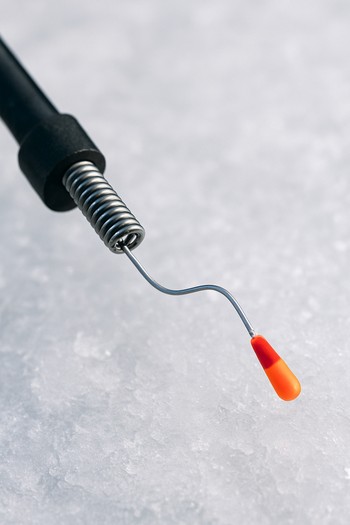 Close view of an ice fishing nod and line above dark water