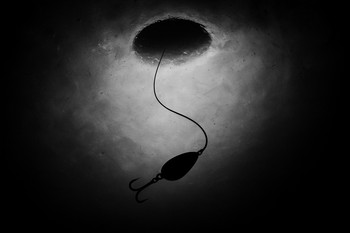 Line and lure drawing a soft arc in the air over the hole