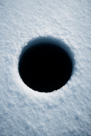 Close view of a single ice hole glowing softly in the dark